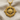Close-up of the handcrafted travel compass pendant in gold vermeil resting gently on textured linen fabric