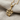 Close-up of a handcrafted gold vermeil twig pendant resting on textured fabric highlighting the diamond leaves