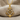 Close up of handcrafted anchor helm pendant showing ship wheel details and sparkling accents resting on textured fabric.