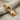 Close-up of 925 sterling silver cat pendant with gold vermeil resting elegantly on textured fabric surface