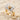 Macro view of a two-tone sterling silver vintage camera ring resting elegantly on beach sand and shells