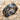 Celtic Braid Wedding Ring, black rhodium, product view on sand