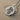 Bird Letter O Pendant, polished silver, on sand and shell