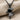 Dancing Doll Pendant, black rhodium plated, front view on fabric