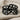 Embracing Wings Ring, black rhodium plated, front view on linen