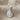 Conch spiral shell earring, polished silver, front view on neutral fabric