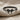 Petite Bow Ring, black rhodium, front view on textured fabric
