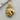 Close-up of the intricately detailed gold vermeil crowned lion pendant resting on a textured wooden surface