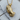 Praying hands pendant featuring detailed 3D craftsmanship resting on a textured wooden log slice next to a twig