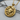 Close-up angled view of the handcrafted Scorpio zodiac pendant resting on a textured wooden branch surface