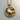 Close-up of the intricately carved gold Cancer zodiac pendant resting on a textured circular wooden surface.