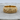 Close-up of gold vermeil fighting panthers ring resting on a textured wooden surface highlighting craftsmanship.