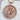 Detailed view of the expecting mother pendant resting on a textured white stone highlighting the sparkling belly stones.