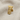 Close-up of gold vermeil Göbeklitepe lapel pin resting on beige linen fabric revealing deep oxidation and textures