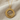 Detailed macro view of the minimalist Anatolian sun disk pendant resting on a soft woven fabric surface
