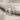 Hittite Double Headed Eagle Earring, polished silver, front view on fabric