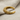Close-up of textured bull horn ear cuff resting on linen fabric showing detailed craftsmanship and curve