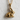 Sitting Rabbit Pendant in gold vermeil, product photo against textured wall