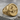 Winged bull faravahar signet ring, gold vermeil, front view on stone surface
