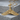 Seated Isis Pendant, gold vermeil, front view on concrete display