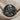 Benjamin Franklin Ring, black rhodium plated, front view on textured fabric