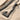 Braided Viking Axe Pendant, black rhodium, angled view on sand