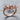 Wire mechanical skull ring, rose gold finish, three-quarter view on wood