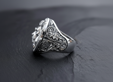 Side profile of silver lion ring showing intricate floral scrollwork engraving and oxidized finish on the band