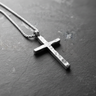 Rustic 925 sterling silver cross necklace with hammered finish displayed on dark slate background