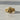 Gold vermeil grim reaper ring with hooded skull and floral band details on concrete background