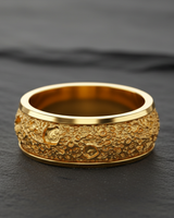 Gold vermeil lunar crater ring featuring textured moon surface design on black background
