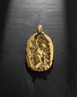 Gold vermeil self made man pendant featuring a muscular figure carving himself out of stone on dark background
