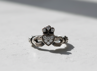 Front view of handcrafted silver Claddagh ring showing detailed hands holding a pavé-set heart and crown design