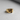 Gold vermeil on silver rift signet ring featuring textured jagged center design on grey surface