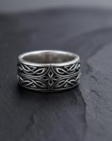 Front view of 925 sterling silver Celtic cross ring with interwoven knot patterns on black slate background