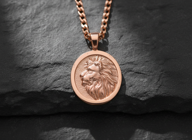Rose gold plated silver lion pendant featuring a detailed profile relief of a lion head on a dark textured stone background