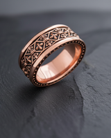 Side view of handcrafted band ring showing detailed relief work in rose gold finish