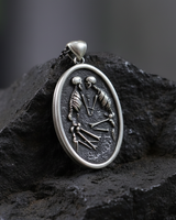 Oxidized 925 sterling silver medallion with skeleton couple design representing till death do us part on textured rock