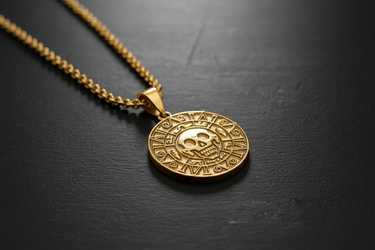 Gold vermeil Aztec skull pendant featuring intricate calendar details on black background