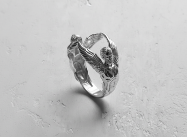 925 sterling silver angel sculpture ring featuring two winged figures connecting at the top on a white background