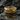 Close-up of gold vermeil Creation of Adam ring resting on a dark wet rock with a clear water reflection