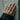 Double Dolphin Tail Ring worn on model's hand against a textured wall