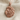 Curled Mane Lion Head Pendant, rose gold, product photo on fabric
