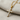 Close-up of elegant diamond cross pendant resting on textured fabric showing detailed gem setting craftsmanship