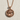 Virgo Zodiac Medallion Pendant, rose gold, front view on textured surface