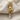 Close-up of the handcrafted vine goddess pendant in gold resting on textured fabric highlighting the stones