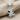 Dancing Doll Pendant, polished silver, front view on fabric