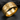 Macro view of the striking gold vermeil freedom military ring resting on dark slate displaying engraved letters