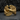 Angled close-up of gold rising phoenix ring highlighting the sculpted high relief bird design against dark stone