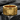 Close-up of the handcrafted gold vermeil Pride statement ring resting on a dark textured charcoal background